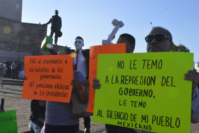 Foto: Samuel Herrera Jr. Los manifestantes portan letreros contra el alza a la gasolina. 