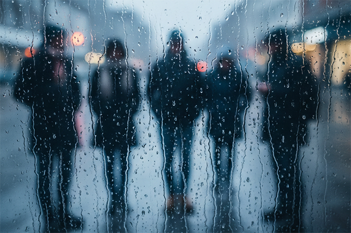 Personas abrigadas caminando bajo la lluvia por el frente frío 32 en México