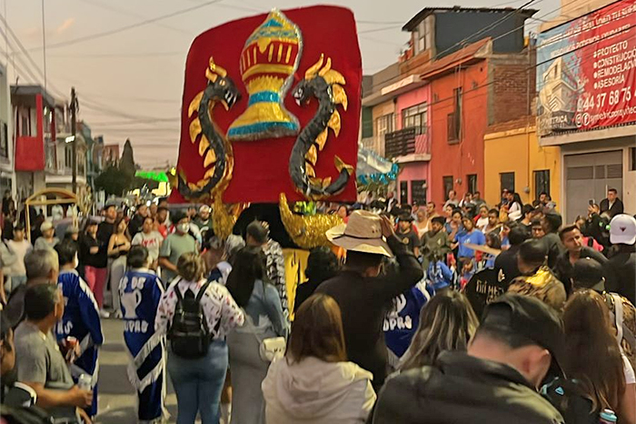 Torito de petate bailando en una colonia de Morelia rodeado de participantes y elementos de la Policía Morelia.