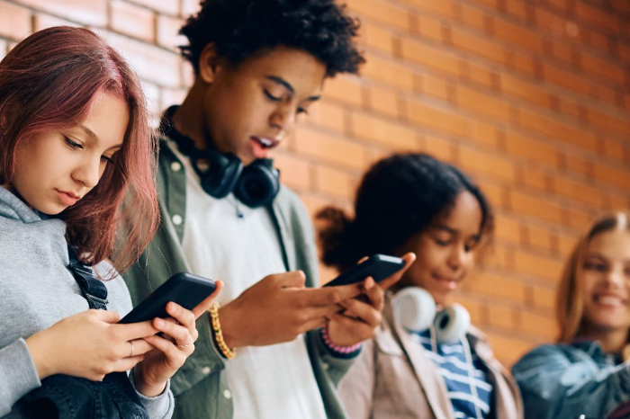 Joven utilizando un dispositivo móvil con gráficos que representan el bienestar emocional y la salud mental digital.