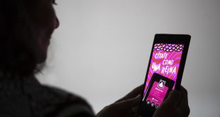 Una persona usando una aplicación de citas en su celular con iconos de corazones.