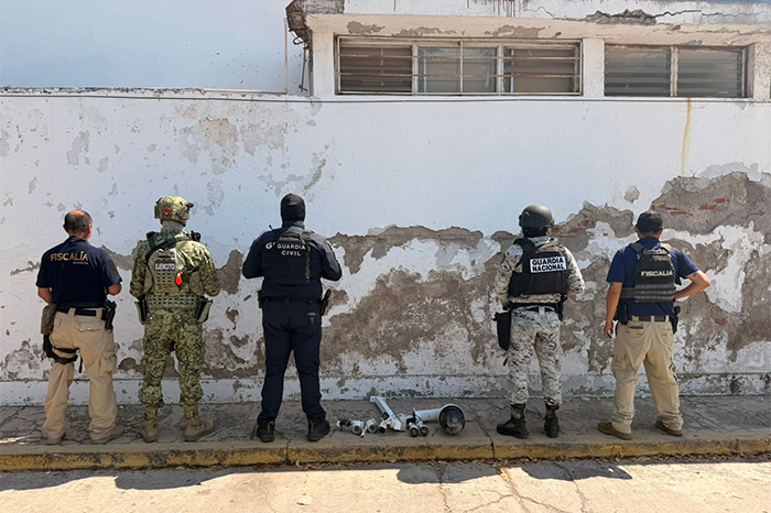 Elementos de la FGE y Guardia Nacional retirando cámaras ilegales de postes en Apatzingán.