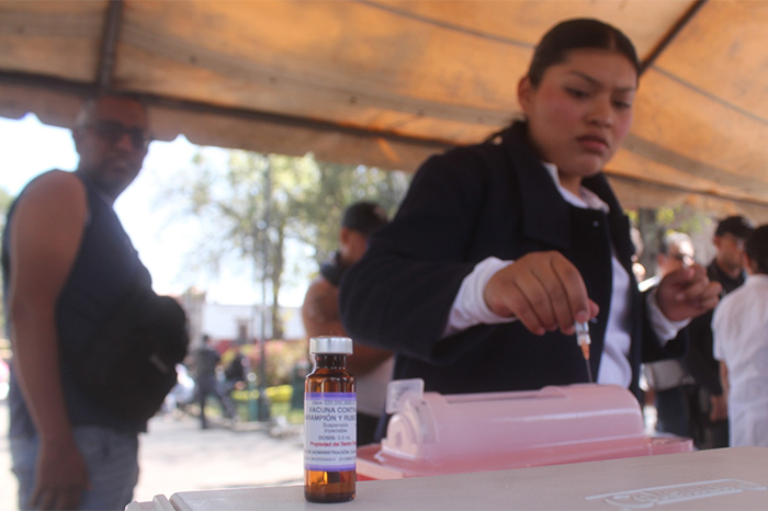 Personal de salud aplicando vacuna contra el sarampión a un adulto en un módulo de salud en México.