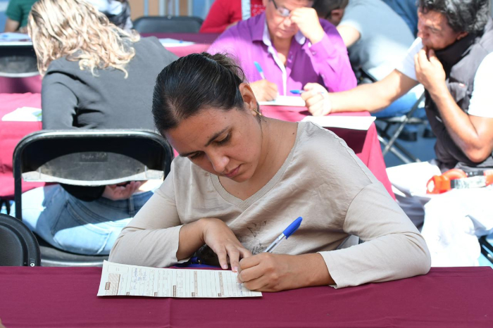 Personas en una feria de empleo recibiendo orientación laboral y revisando vacantes en Michoacán.