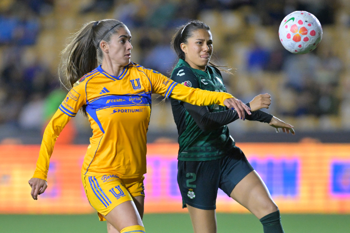 ugadoras de la Liga MX Femenil en disputa por el balón durante un partido oficial. La imagen representa la competitividad y el crecimiento del fútbol femenino a nivel global.