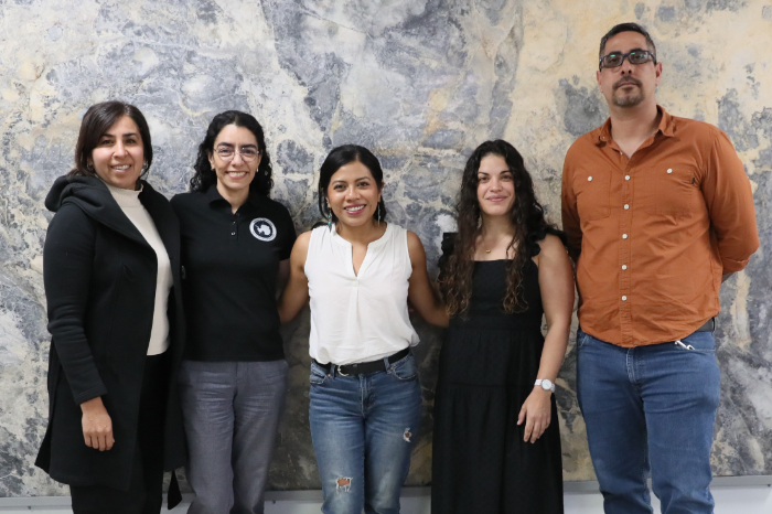 Integrantes de la Primera Campaña Científica Antártica Mexicana (CAMEX 1) posando frente a un muro de piedra.