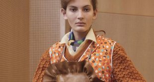 Modelo en pasarela vistiendo una bata de flores inspirada en la indumentaria doméstica tradicional de las amas de casa.