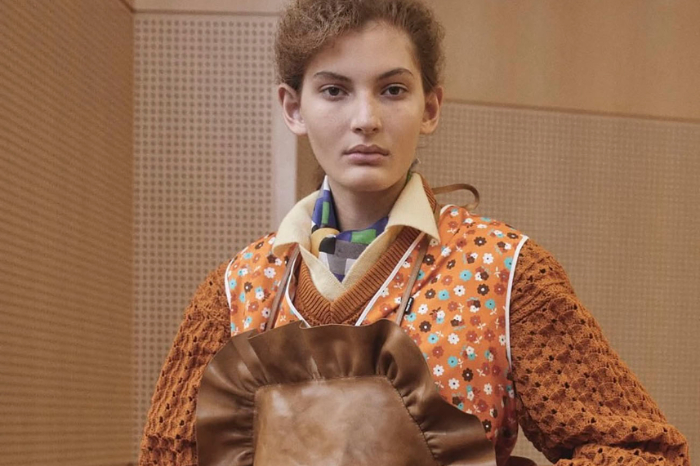 Modelo en pasarela vistiendo una bata de flores inspirada en la indumentaria doméstica tradicional de las amas de casa.