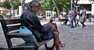 Un hombre intenta buscar señal en su teléfono móvil en una calle de La Habana durante un corte de luz.