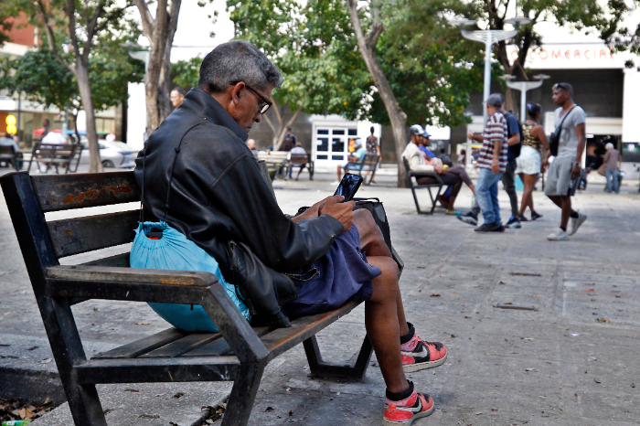 Un hombre intenta buscar señal en su teléfono móvil en una calle de La Habana durante un corte de luz.