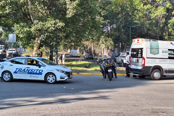 Peritos de la Fiscalía y elementos de seguridad en el lugar del accidente de motocicleta en el Libramiento de Uruapan.