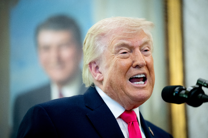 El presidente Donald Trump hablando con intensidad frente a un micrófono durante una conferencia de prensa.