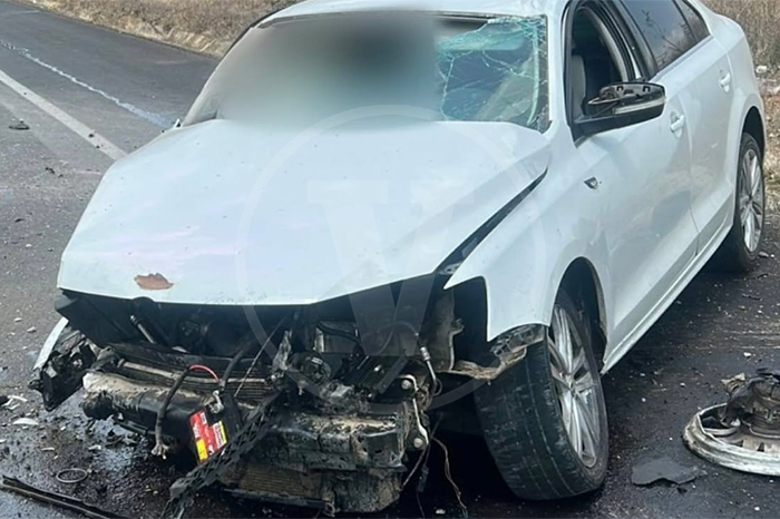 Vehículo color blanco con la parte frontal destrozada tras un accidente en la carretera Morelia-Pátzcuaro, resguardado por patrullas.