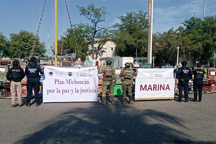 Elementos de la FGE y la Marina resguardando máquinas tragamonedas aseguradas en un comercio de Lázaro Cárdenas.