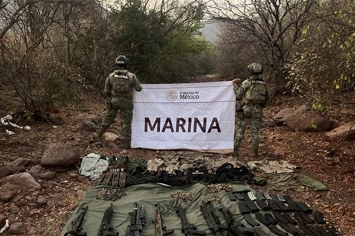 Elementos de la Secretaría de Marina (SEMAR) custodiando armamento, equipo táctico y vehículos asegurados en Michoacán.