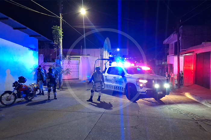 Patrullas y peritos resguardando el taxi Kia blanco de la organización Trébol tras el asesinato de su conductor en Uruapan.