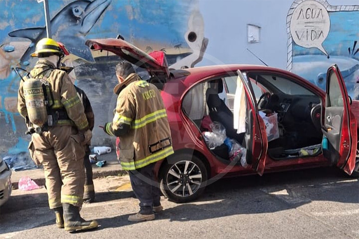 Vehículo Nissan March color rojo con daños por intento de incendio en la calle Pino Suárez de Uruapan.