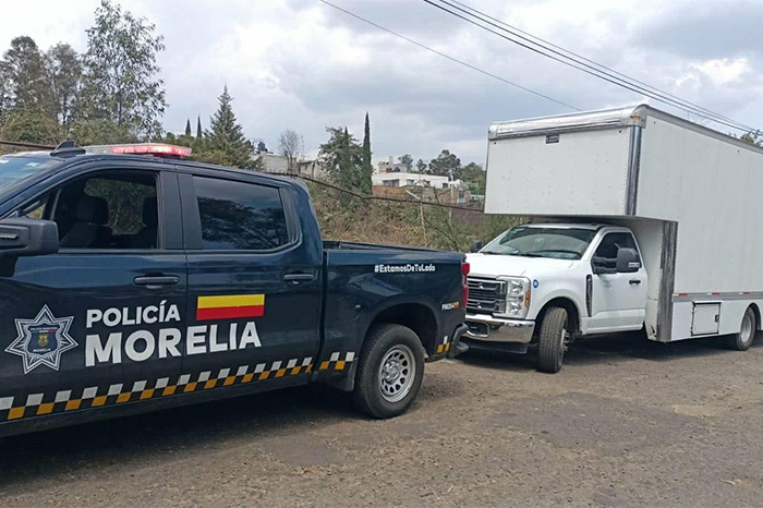 Patrulla de la Policía Morelia resguardando una camioneta Ford blanca recuperada en la colonia Bosques de Oriente.