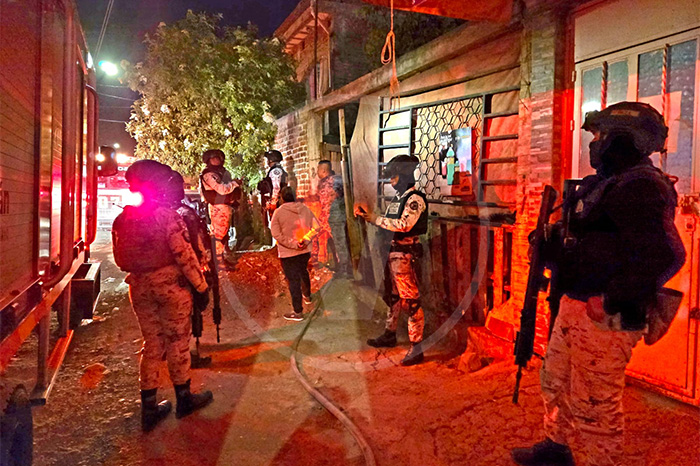 Elementos de la Guardia Nacional y Bomberos Municipales trabajando en la sofocación de un incendio en una vivienda de Zamora.