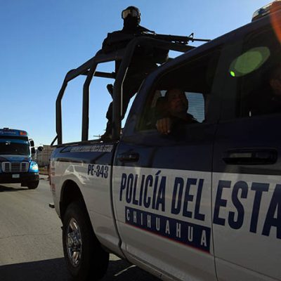 Patrullas de la Agencia Estatal de Investigación y vehículos de emergencia en una carretera de Chihuahua.