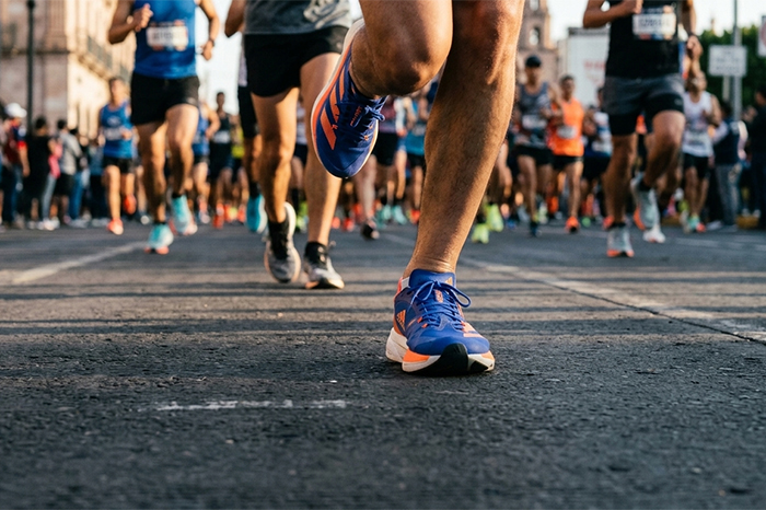 Primer plano de corredores con tenis Adidas participando en la Carrera Adidas 2026 en Morelia.