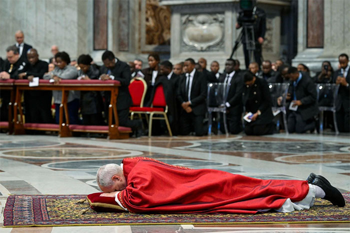 El papa León XIV orando postrado ante el Altar de la Confesión en la Basílica de San Pedro.