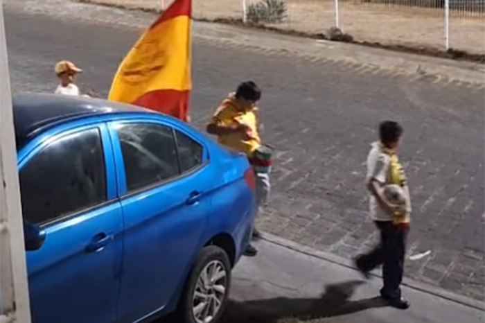 Cuatro niños de Morelia con bandera rojiamarilla y un bote-tambor alentando al Atlético Morelia en Villas del Pedregal.