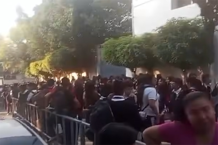 Elementos de la Policía Morelia y padres de familia supervisando la Operación Mochila en la entrada de la Secundaria Técnica 65.