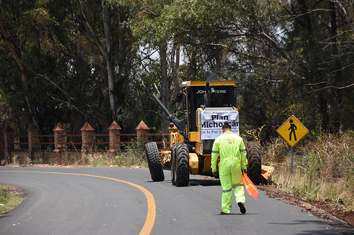 Maquinaria pesada realizando trabajos de bacheo y repavimentación en un camino rural de Michoacán.