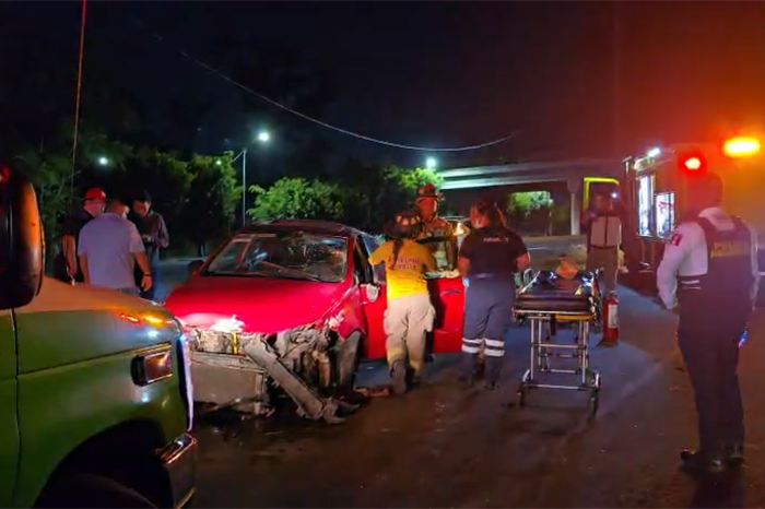 Automóvil Seat Ibiza de color rojo volcado sobre el carril lateral del Libramiento de Morelia.