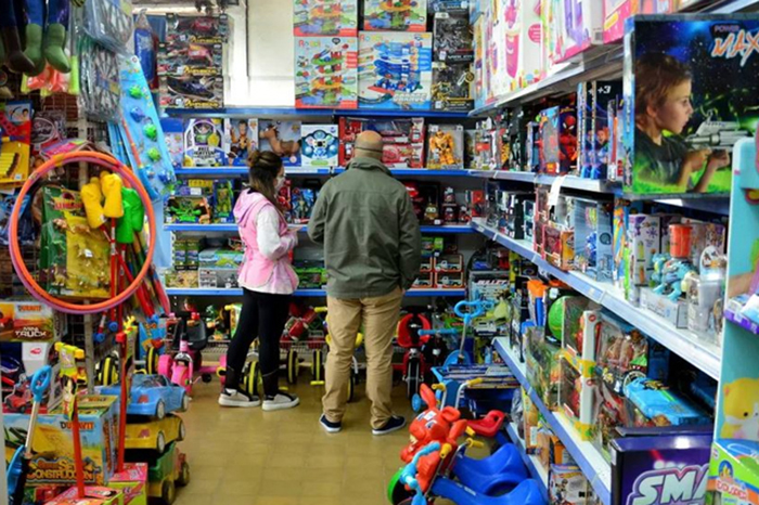 Familias realizando compras de juguetes y dulces en un centro comercial por el Día del Niño.