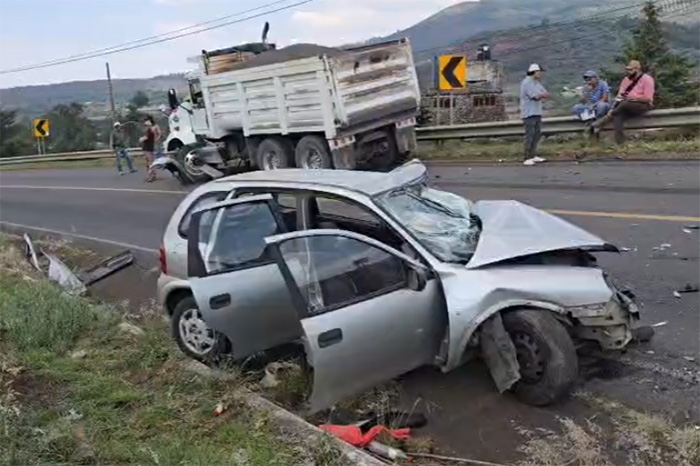 Paramédicos y bomberos rescatando a un conductor prensado en un Chevy tras chocar con un camión en la carretera Morelia-Quiroga.