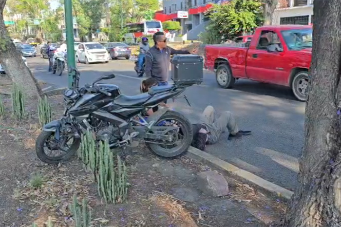 otociclista siendo auxiliado tras derrapar para evitar chocar contra un torton en la avenida Madero Poniente de Morelia.