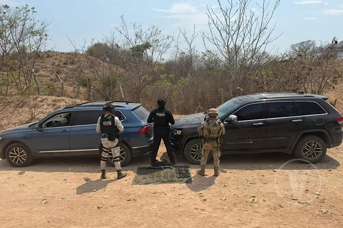 Vehículos asegurados y armamento de alto poder decomisados durante un operativo en Lázaro Cárdenas.