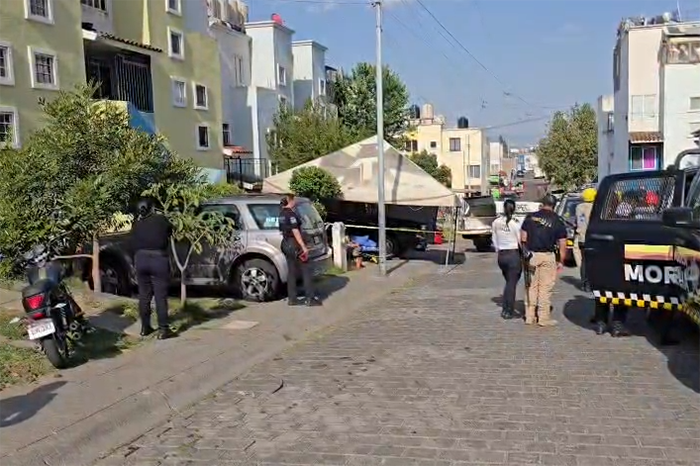 Elementos de la Policía Morelia y la Guardia Civil acordonando la calle Seis Oriente en Villas del Pedregal tras un ataque armado.