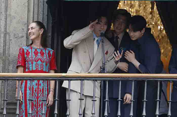 Los siete integrantes del grupo surcoreano BTS posando junto a la presidenta de México en las instalaciones de Palacio Nacional.