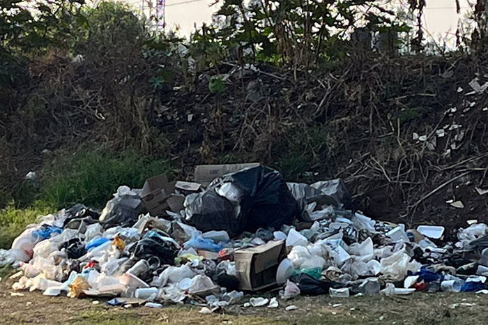 Contenedores saturados y montones de desechos sólidos acumulados en un área verde recreativa de Morelia.