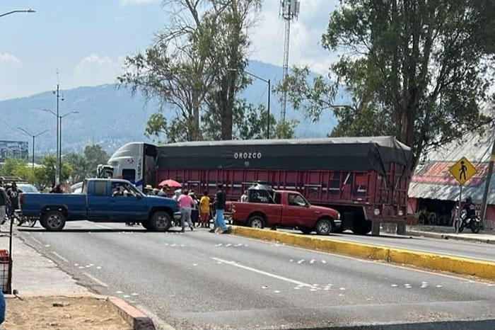 Tráiler cruzado bloqueando la circulación vehicular sobre una vialidad principal en el municipio de Uruapan.