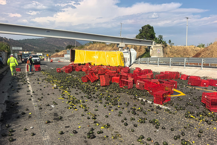 Camión de carga accidentado sobre su costado con cajas de fruta esparcidas en el asfalto de la autopista Siglo XXI.