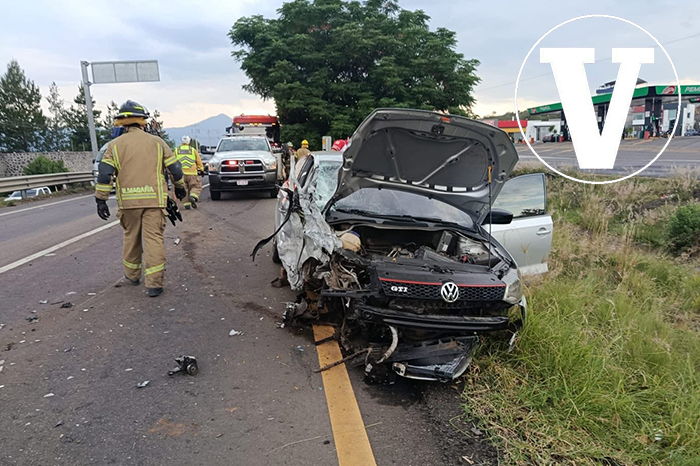 Elementos de vialidad y cuerpos de emergencia resguardando el perímetro de un auto compacto siniestrado en el camellón central.