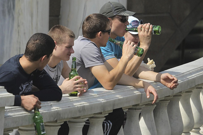 Jóvenes consumiendo cervezas.