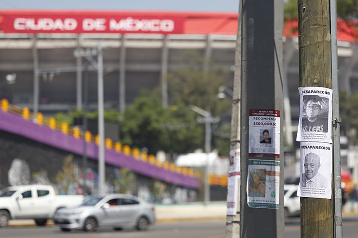 Colectivos de madres buscadoras pegando carteles y cédulas de identidad en las vallas metálicas cercanas al Circuito Estadio Azteca.