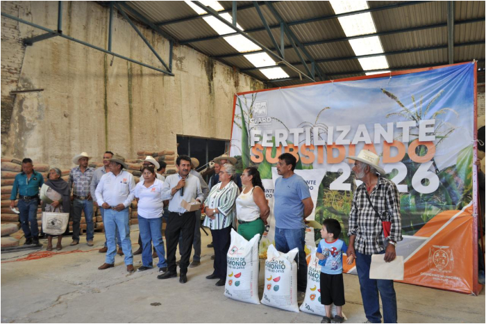 Gabriel Molinero, presidente municipal de Charo, entregando costales de fertilizante a productores locales.