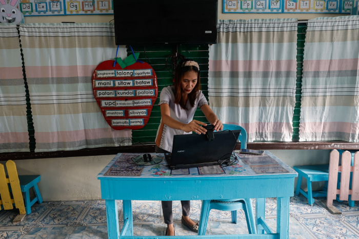 Maestro mexicano utilizando plataforma de gestión escolar en aula digital