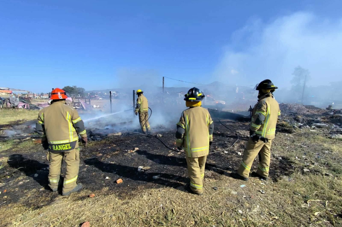 Bomberos de Protección Civil Michoacán apagando el fuego de una casa incendiada en Morelia