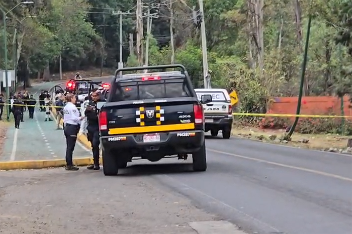 Agentes de la Policía Morelia resguardan la escena del crimen en la antigua carretera a Pátzcuaro.