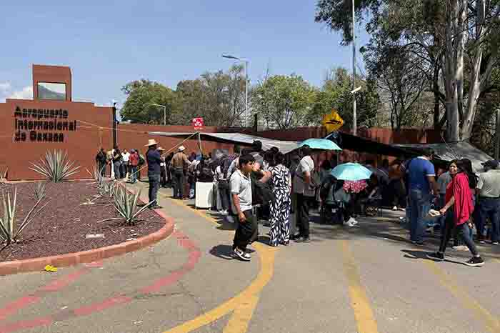 Maestros de la CNTE bloqueando los accesos principales del Aeropuerto Internacional de la Ciudad de Oaxaca con pancartas.