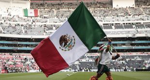 Un animador agita una bandera de México durante un partido amistoso entre México y Portugal en el estadio Azteca (Banorte) de Ciudad de México, el 29 de marzo de 2026.