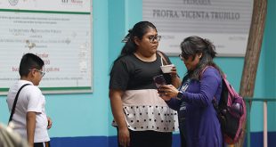 Madres y padres de familia conversando afuera de una escuela secundaria en la Ciudad de México.
