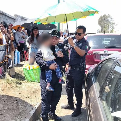 Elementos de Seguridad Vial de la Guardia Civil rescatando a un niño de un vehículo Hyundai gris en Morelia.